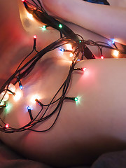 Illaria erotically poses with the Christmas lights all..